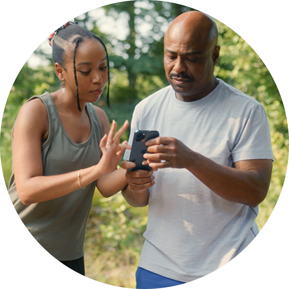 father and daughter looking at phone outside